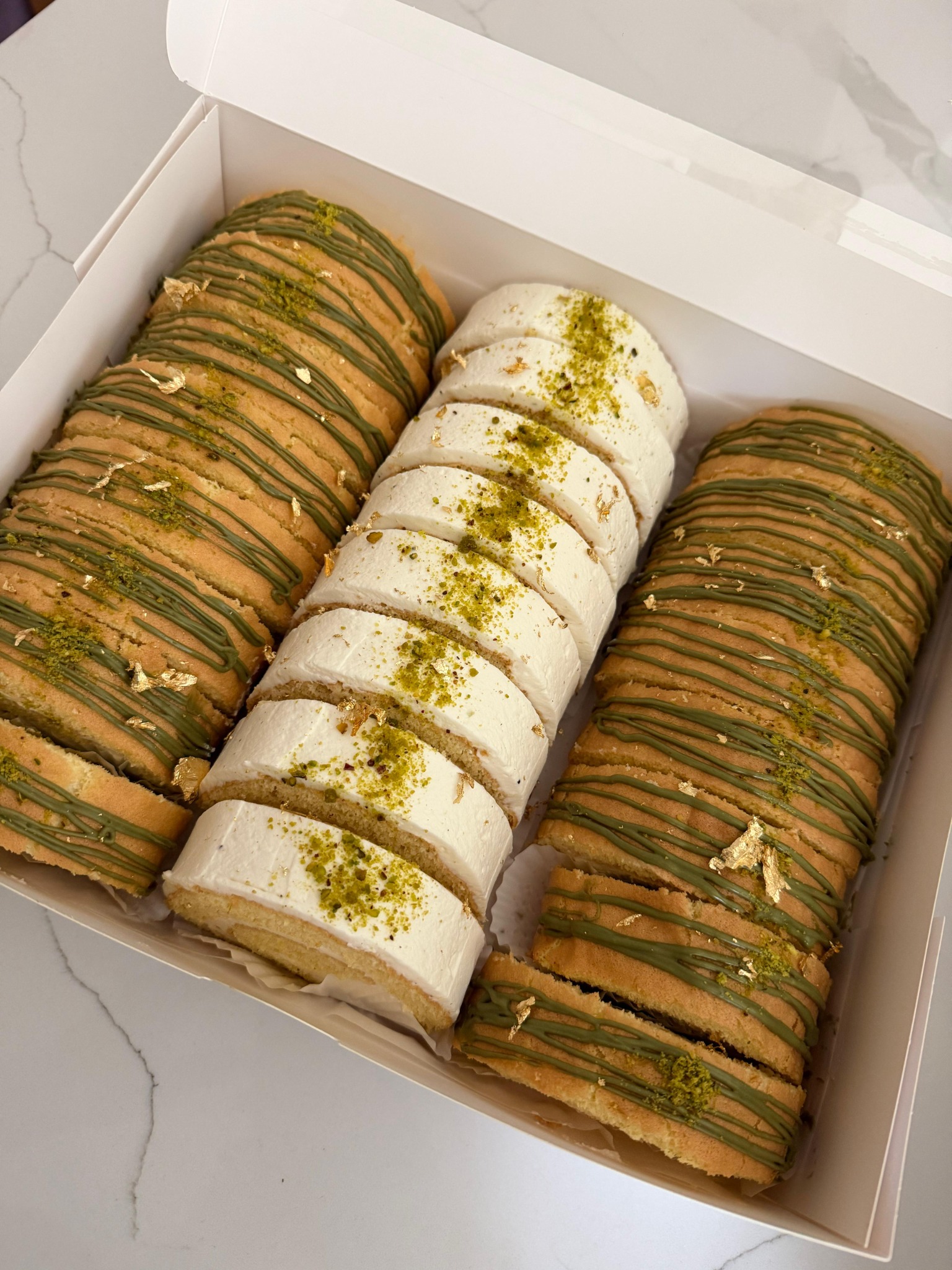 Pistachio and cream cake rolls in a bakery box