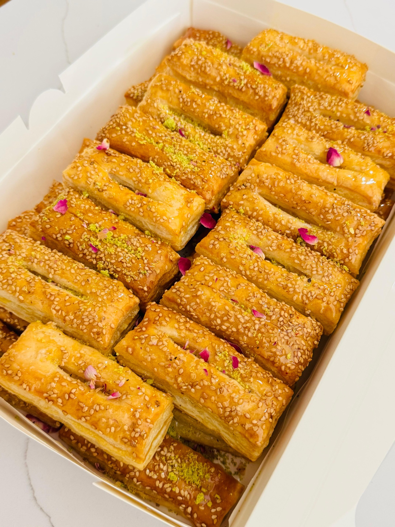 Golden sesame pastries with pistachio and rose petals